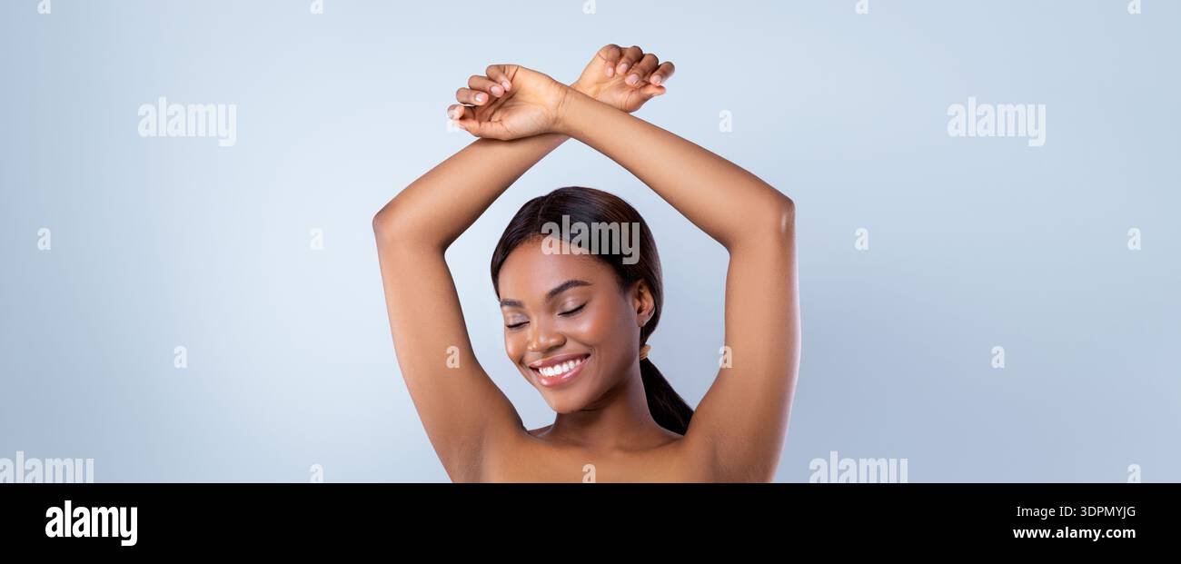 Woman stretches Arms with a Smile in un semplice ambiente da studio durante il giorno Foto Stock