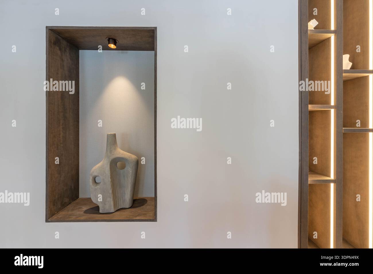 un'immagine di arte in pietra in scaffali di legno illuminati in immobili di lusso mediterranei Foto Stock