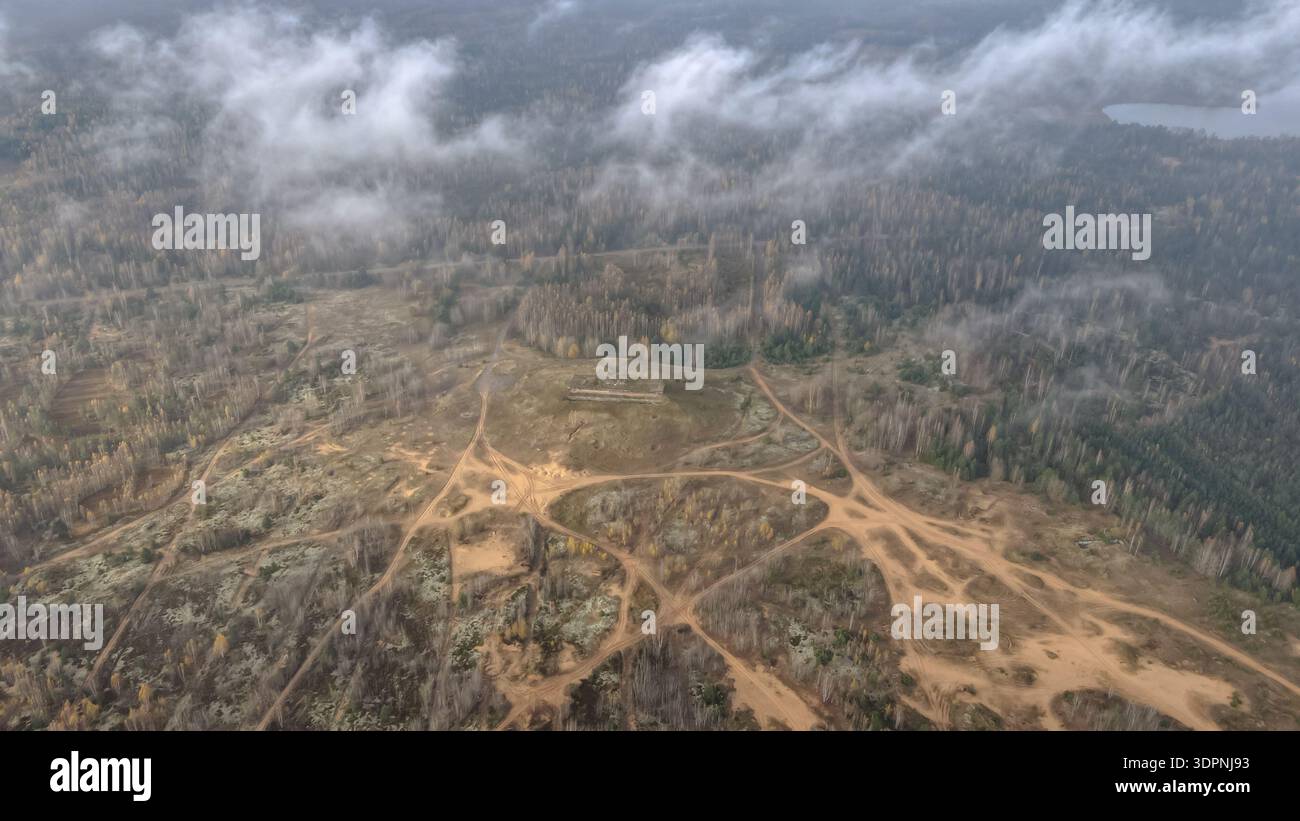 La vista aerea del campo di allenamento di Dretunsky in Bielorussia mostra le piste sabbiose dei veicoli, una posizione di tiro in cemento, terra sfondata, vecchi crateri, clou basso Foto Stock