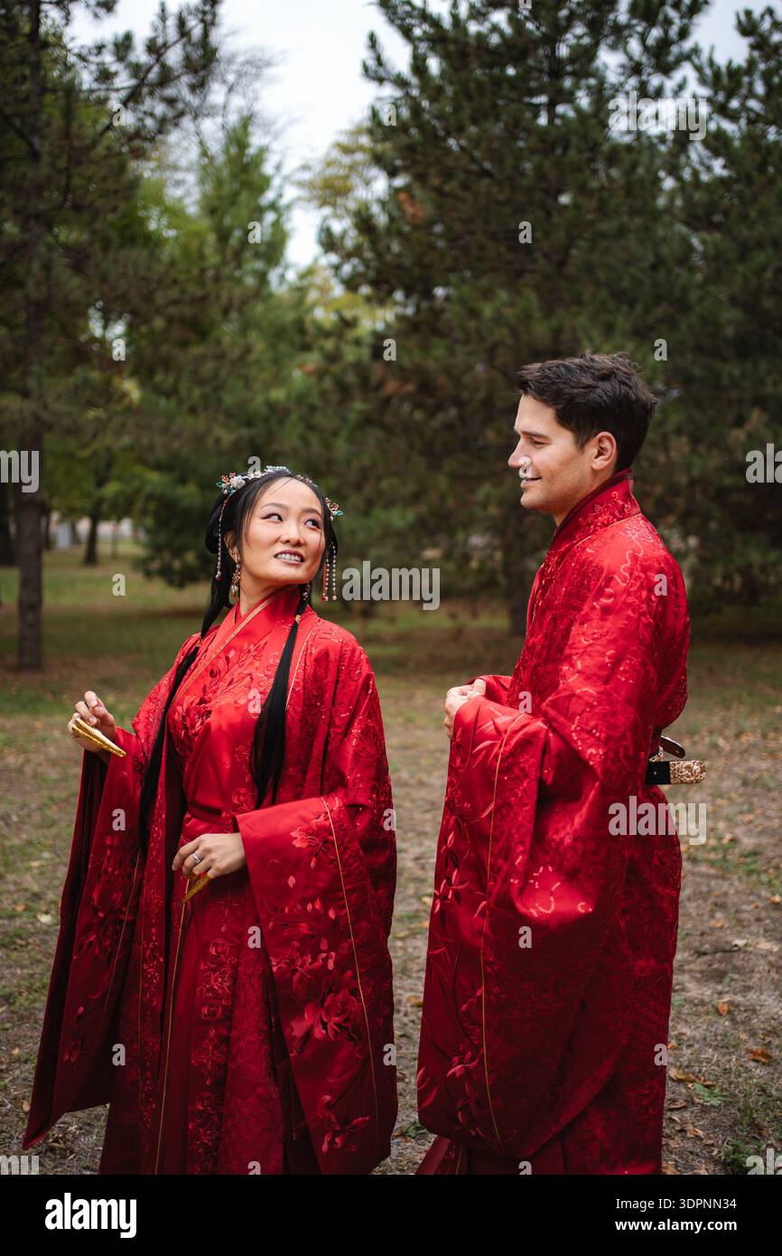Coppie multiculturali che celebrano matrimoni tradizionali cinesi all'aperto Foto Stock
