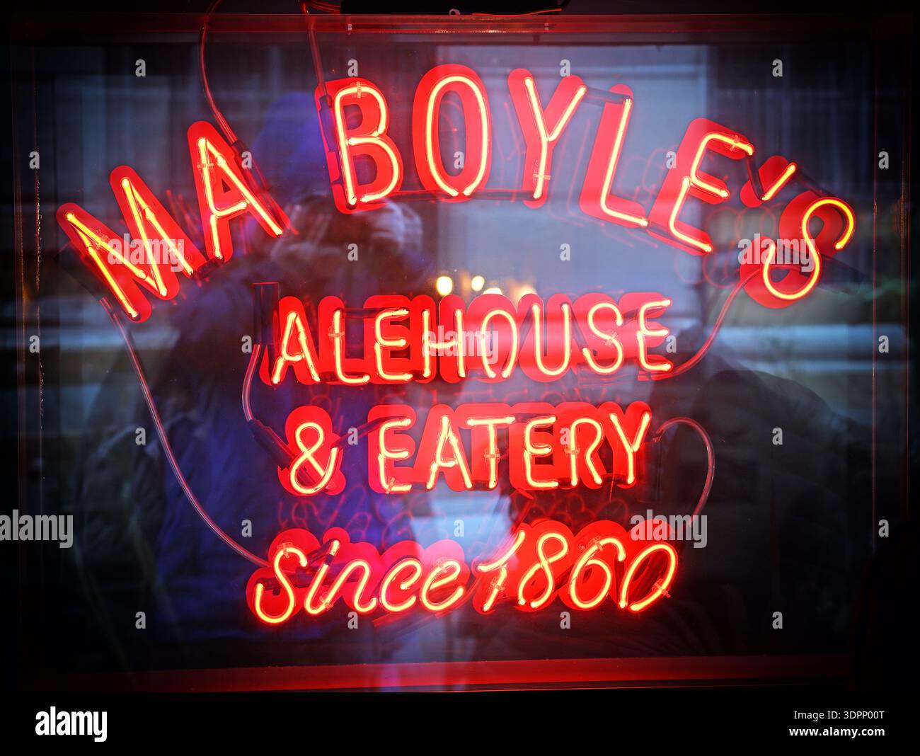 Insegna al neon con la scritta “ma Boyle’s Alehouse & Eatery Since 1860” che si illumina di rosso in una finestra di Liverpool, con riflessi stradali. Foto Stock