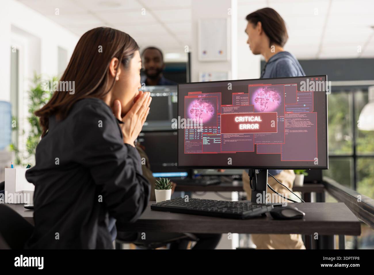 Ritratto del programmatore donna che reagisce all'avviso di errore di allarme sul monitor desktop. La donna copre la bocca nel panico, rappresentando bug software, minacce di attacco informatico e crisi della sicurezza digitale. Foto Stock