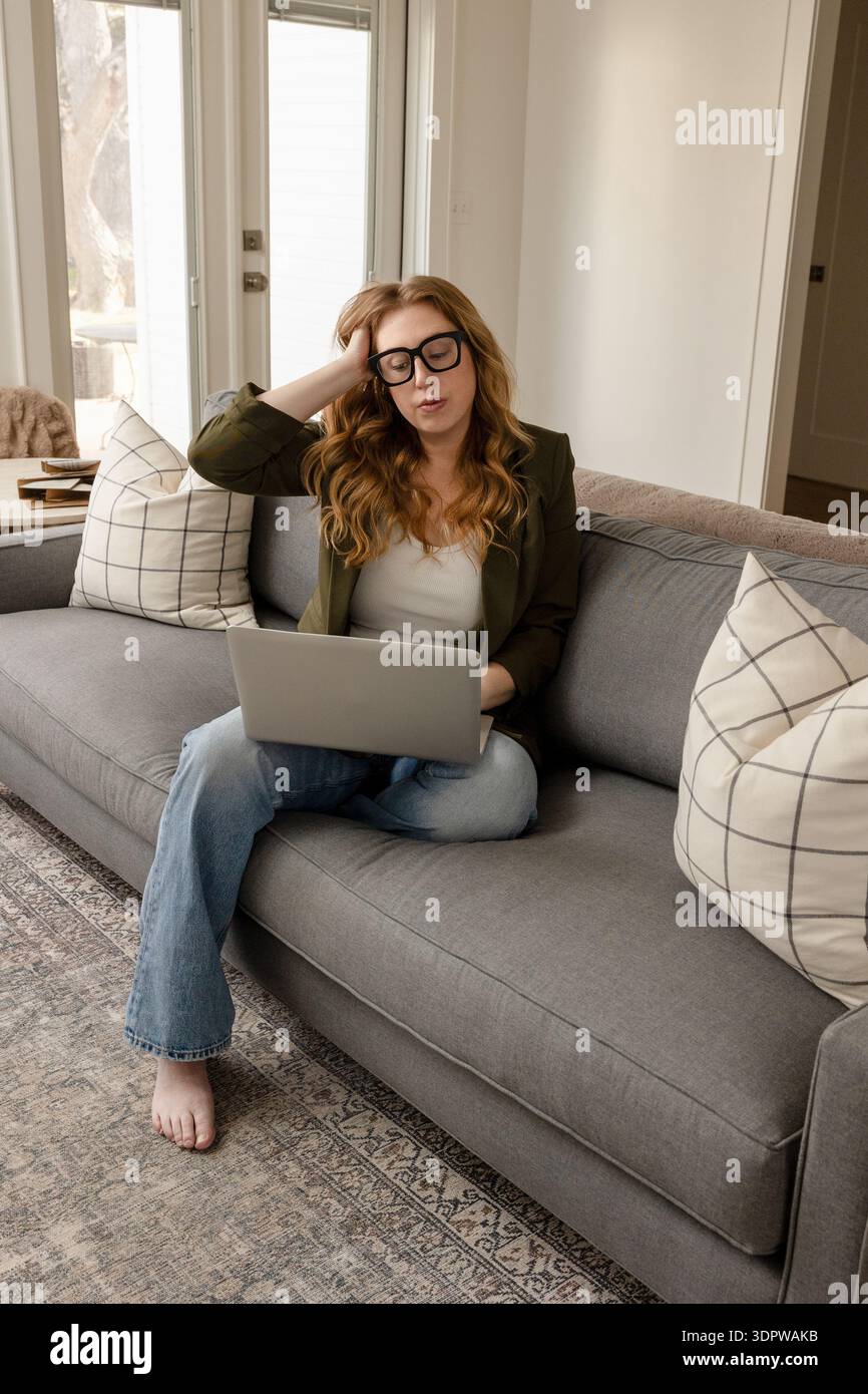 Donna stressata che lavora a distanza da casa Foto Stock