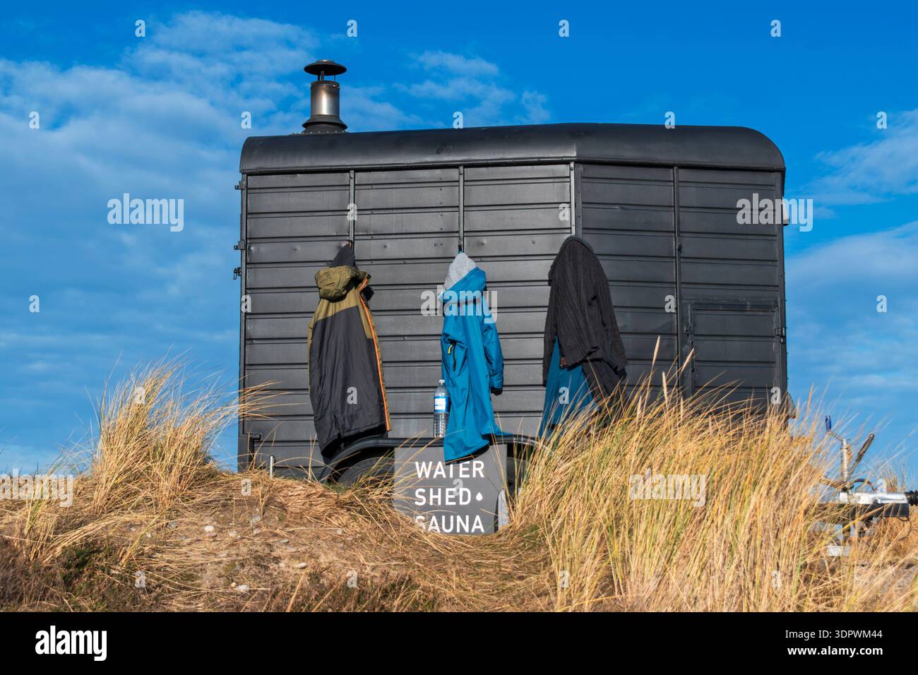 I cappotti Findhorn Moray Scotland sono appesi alla sauna Water Shed in una giornata fredda e soleggiata d'inverno Foto Stock