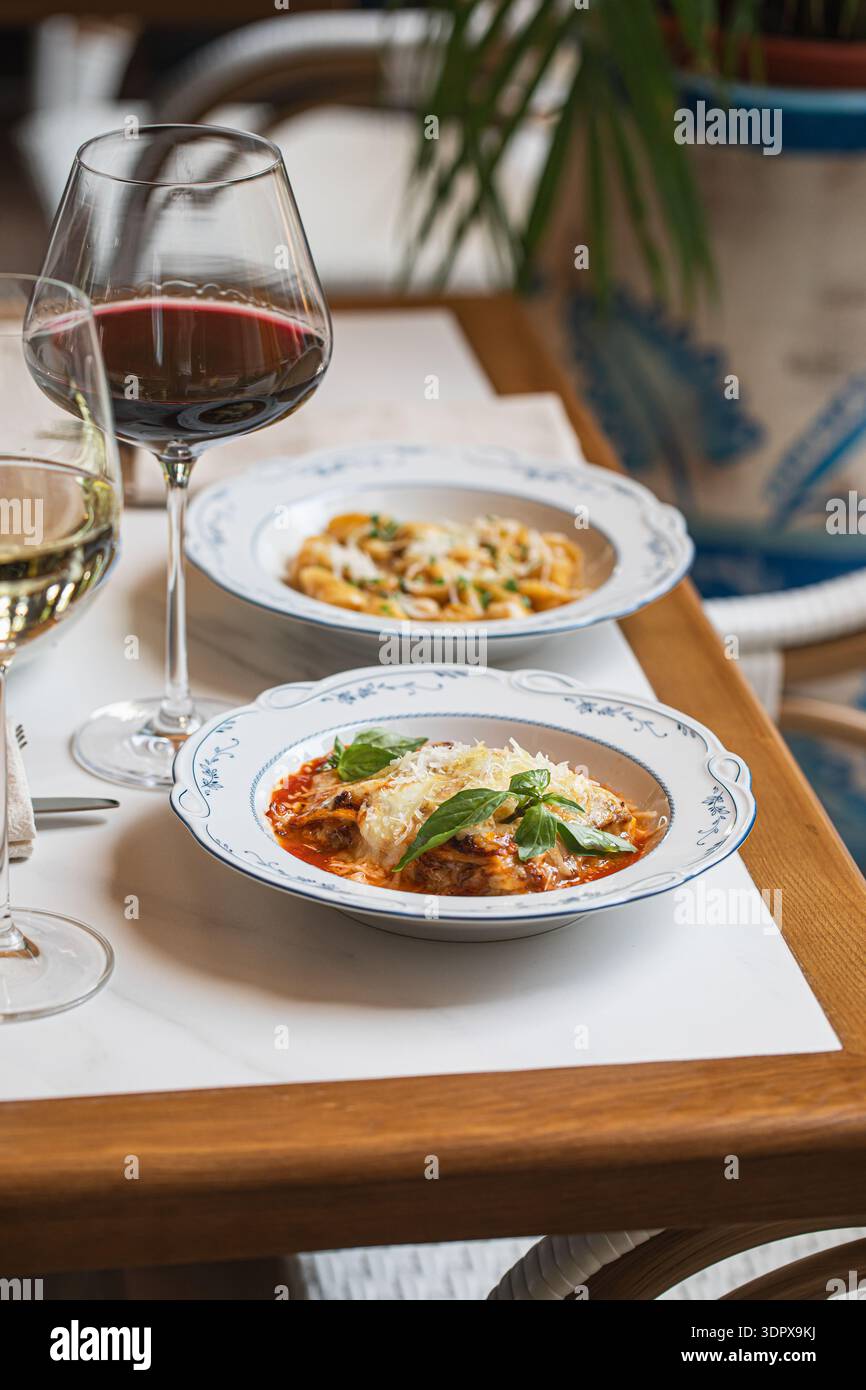 Lasagne italiane servite con vino sul tavolo Foto Stock