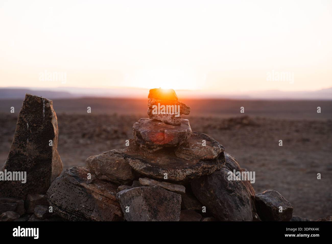 Un'alba mozzafiato illumina un affioramento roccioso nel vasto paesaggio di un deserto africano. L'immagine cattura la bellezza selvaggia dell'Africa su un Foto Stock