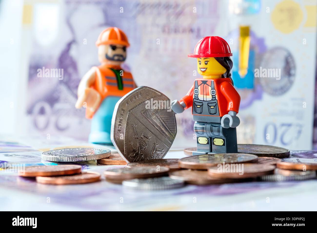 Immagine del concetto : i lavoratori del settore edile "lavorano" con il denaro Foto Stock