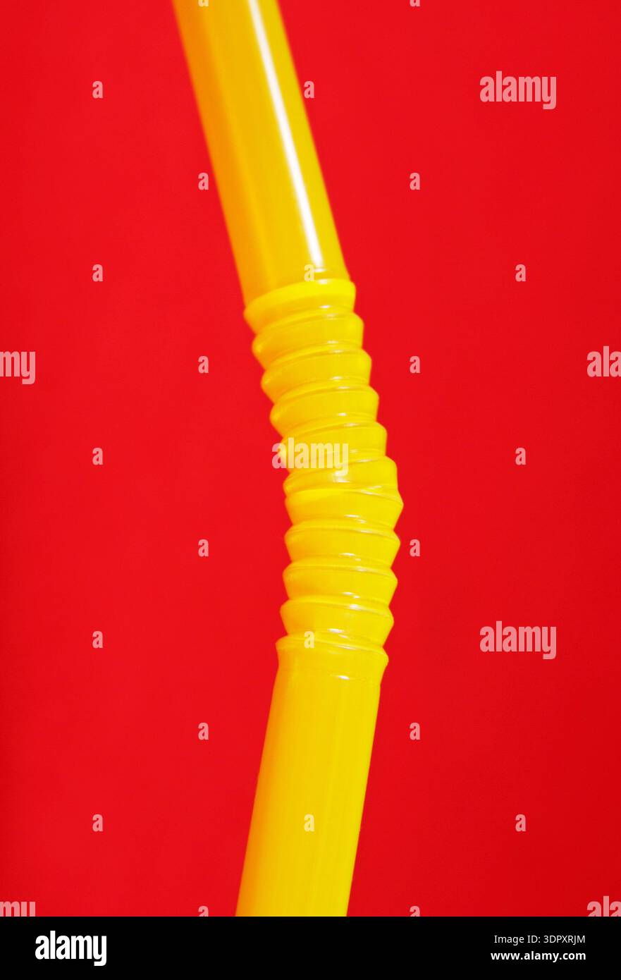 cannuccia di plastica gialla su sfondo rosso Foto Stock