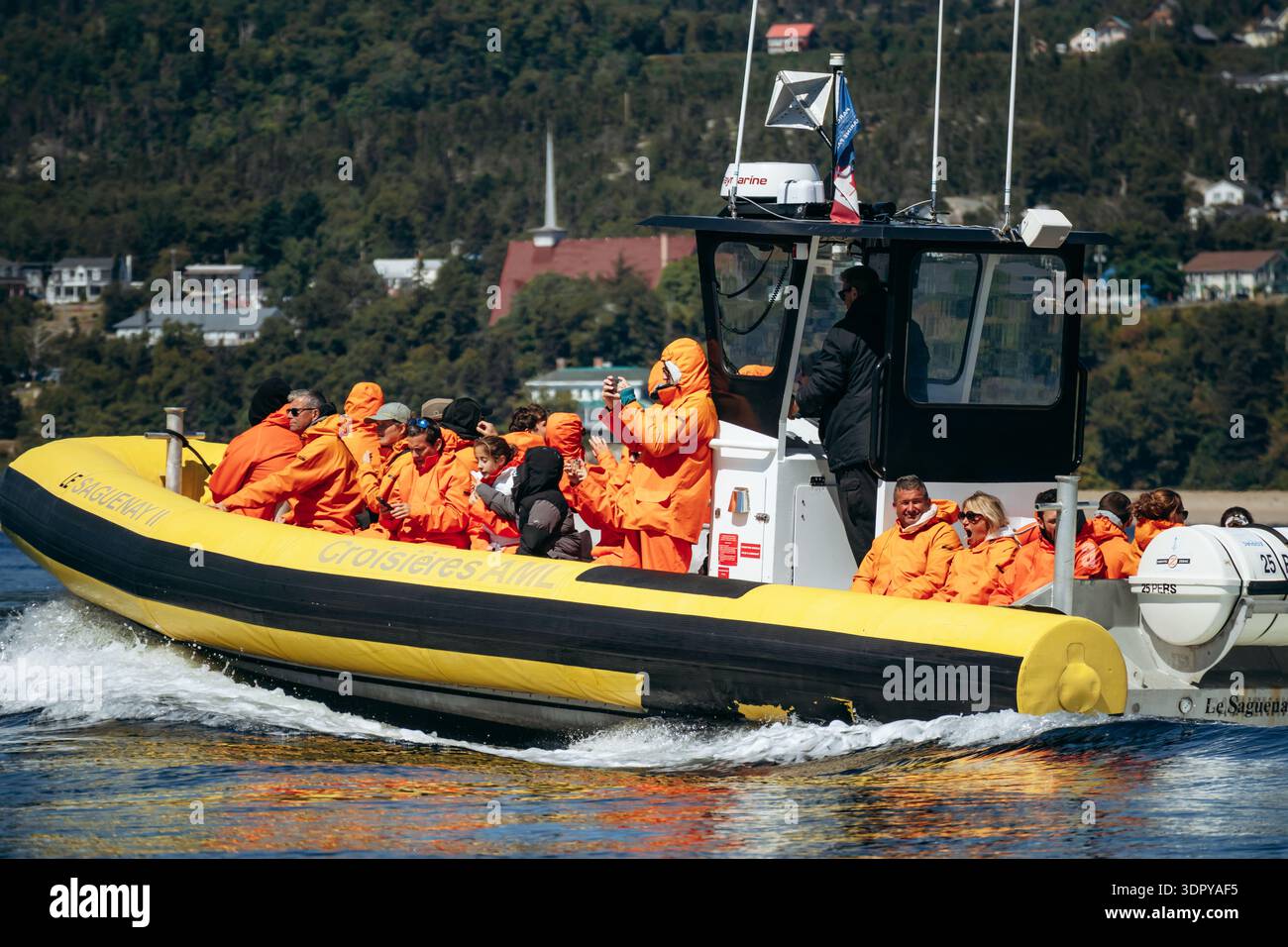 Tadoussac, Canada - 22 agosto 2025: Turisti che indossano giacche arancioni a bordo di gommoni zodiacali gonfiabili durante le escursioni di avvistamento delle balene sulla St Foto Stock