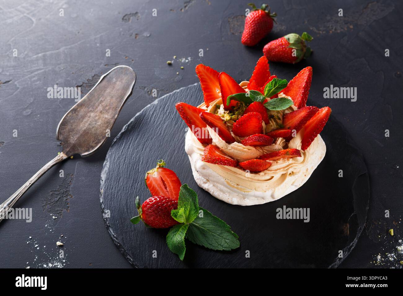 Delizioso dessert a base di meringa, crema e fragole fresche su sfondo scuro Foto Stock