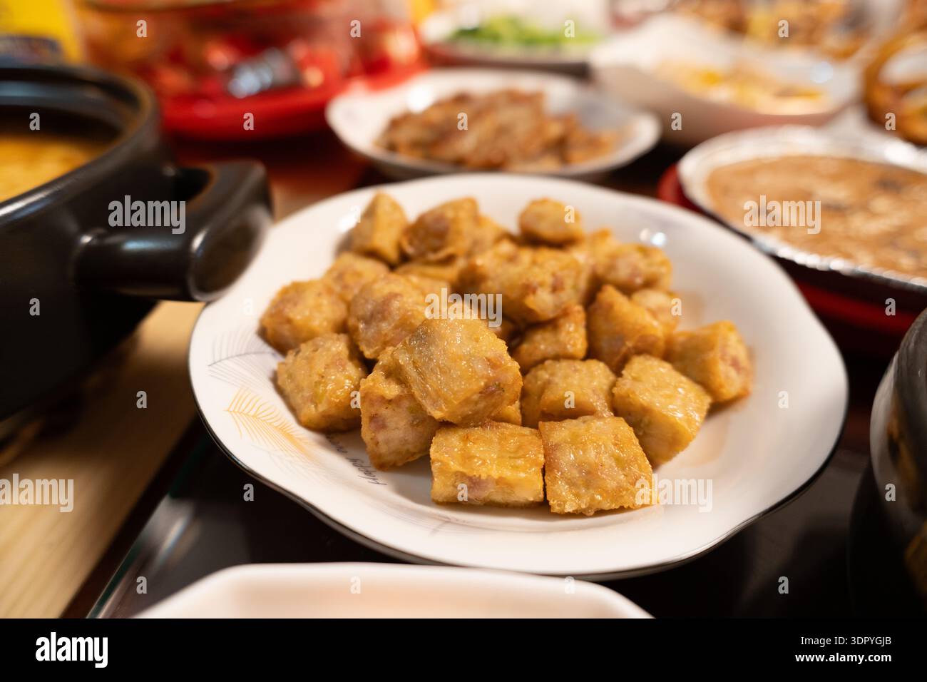 Piatti cinesi di tofu Sichuan su piatti bianchi a tavola con vari contorni Foto Stock