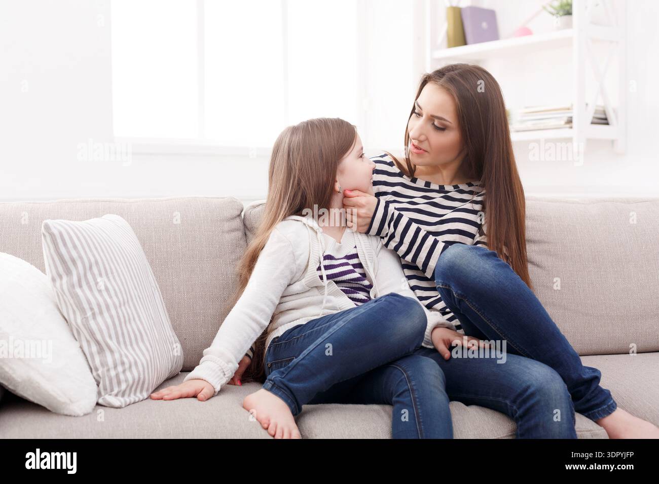 Madre e figlia condividono un momento tranquillo mentre si siedono insieme su un divano Foto Stock