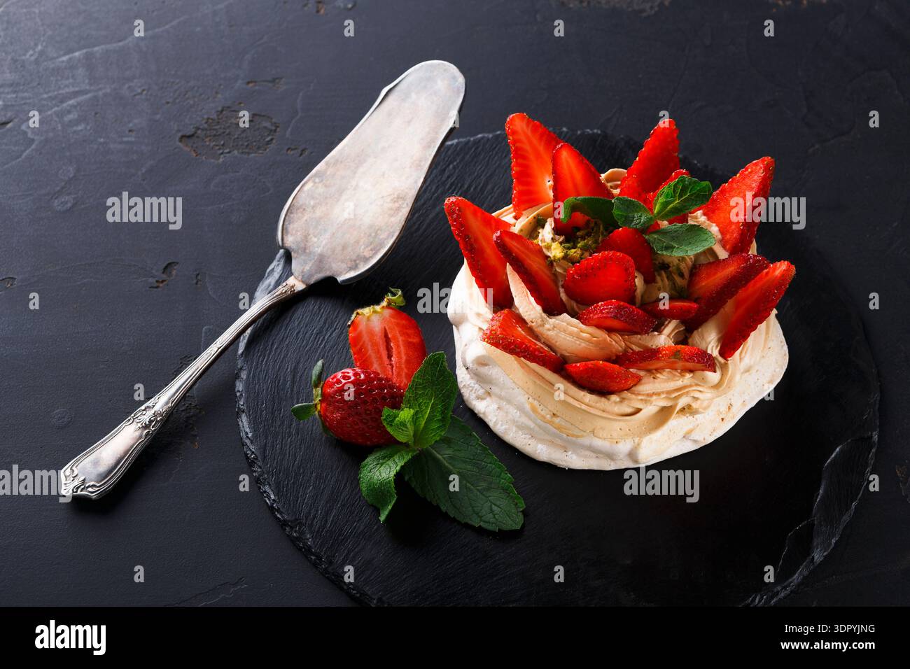 Delizioso dessert a base di meringa, panna e fragole fresche servito su un piatto Foto Stock