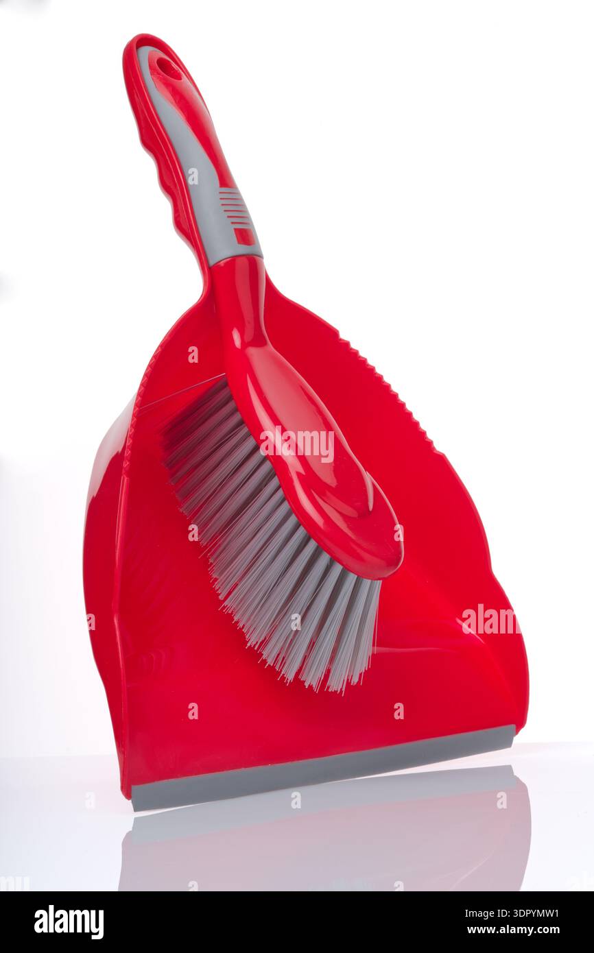 Set paletta e spazzola. Una paletta in plastica rossa e una spazzola. Le impugnature si adattano per creare un pratico set. Foto Stock