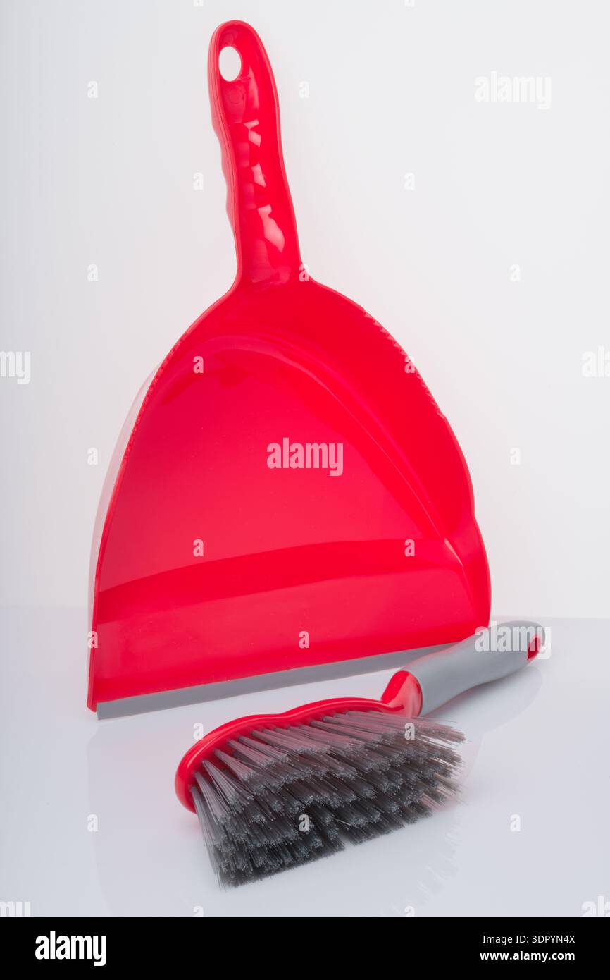 Set paletta e spazzola. Una paletta in plastica rossa e una spazzola. Le impugnature si adattano per creare un pratico set. Foto Stock