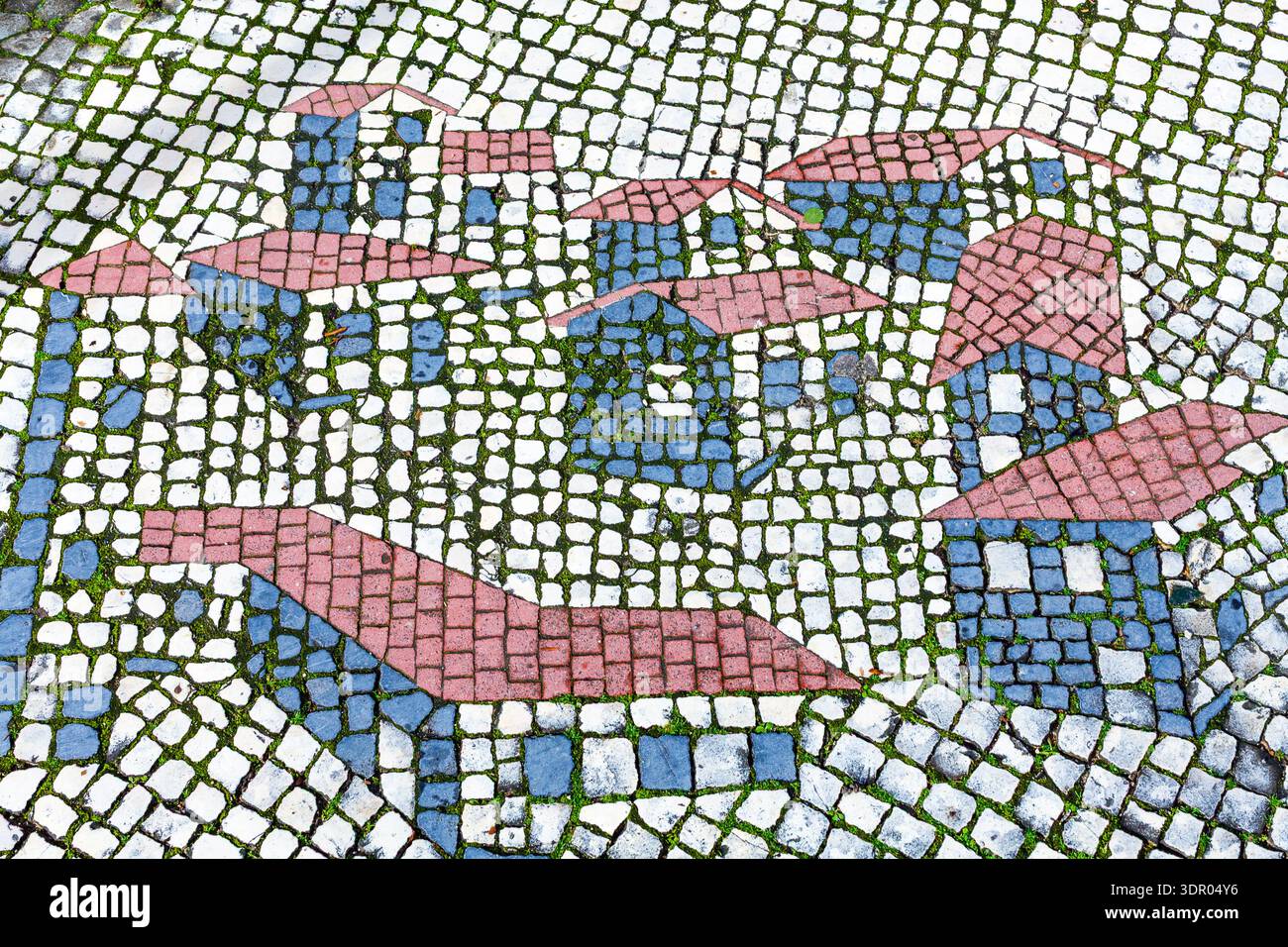 Primo piano ad alto angolo di un tradizionale pavimento a mosaico in pietra che raffigura case stilizzate con tetti rosa e pareti blu, con ciottoli colorati wi-fi Foto Stock