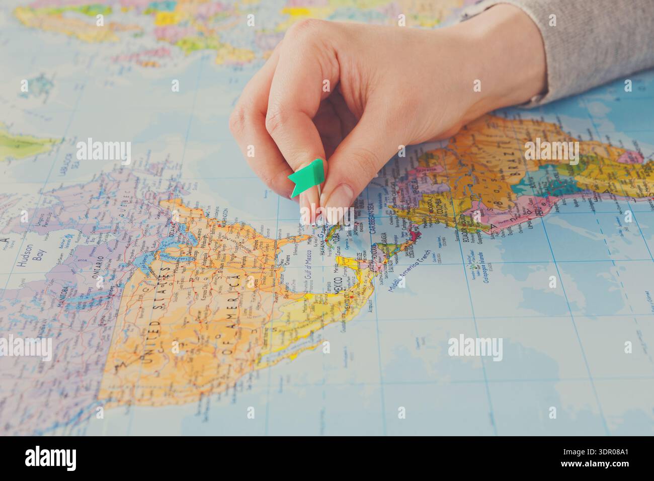 Pianificazione di un viaggio utilizzando una mappa e una spilla per contrassegnare una posizione in America centrale Foto Stock