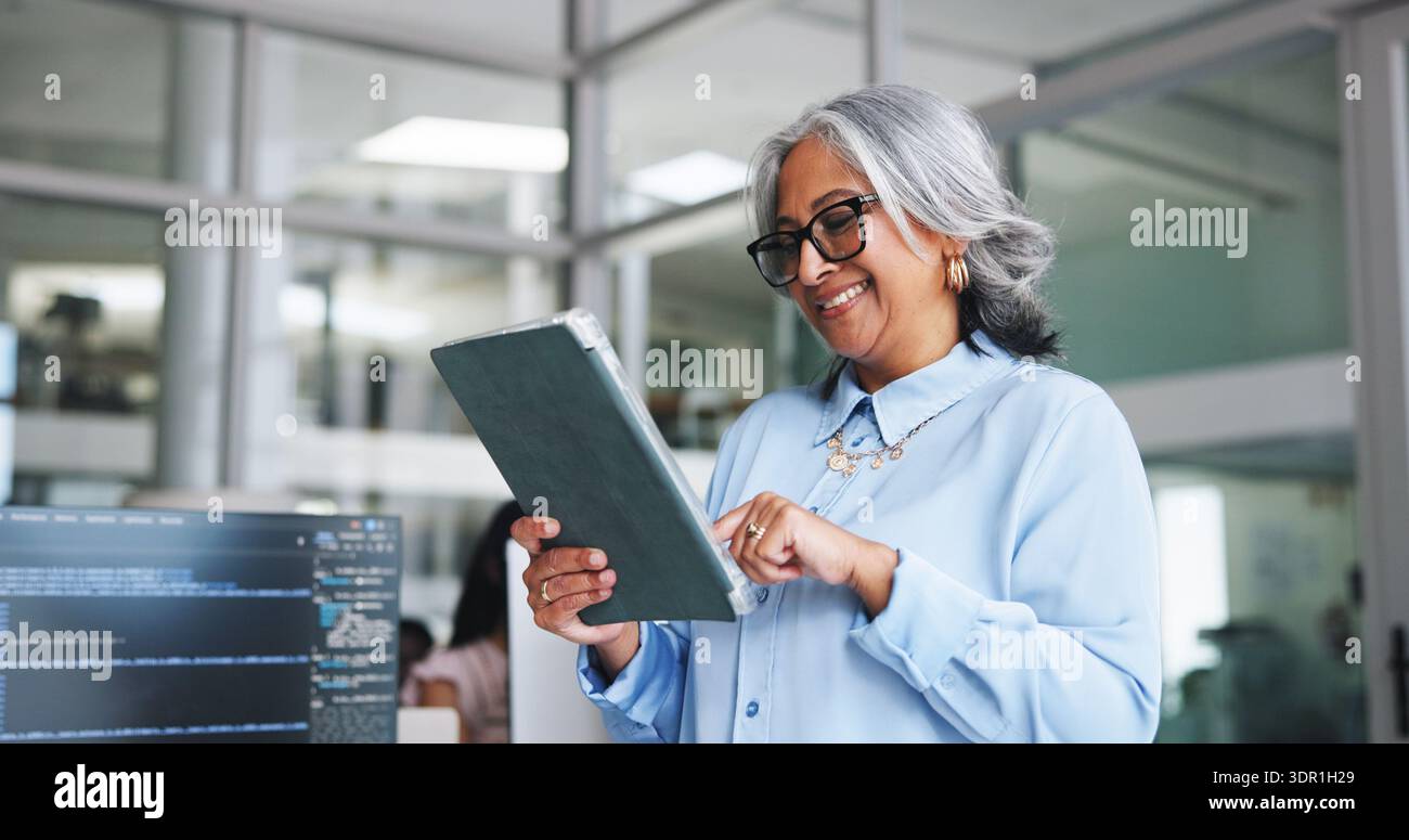 Sorridi, donna e tablet per la programmazione in ufficio per la ricerca, il manuale del software e la codifica. Persona matura, app digitale e risoluzione dei problemi per il sito Web Foto Stock