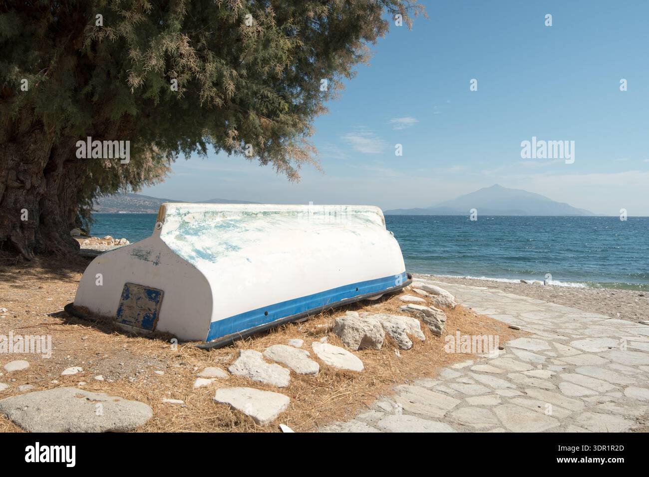 Barca bianca e blu abbandonata sulla costa greca Foto Stock