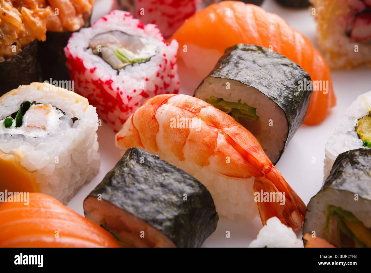 Esplora una collezione di sushi disposti in un set colorato Foto Stock