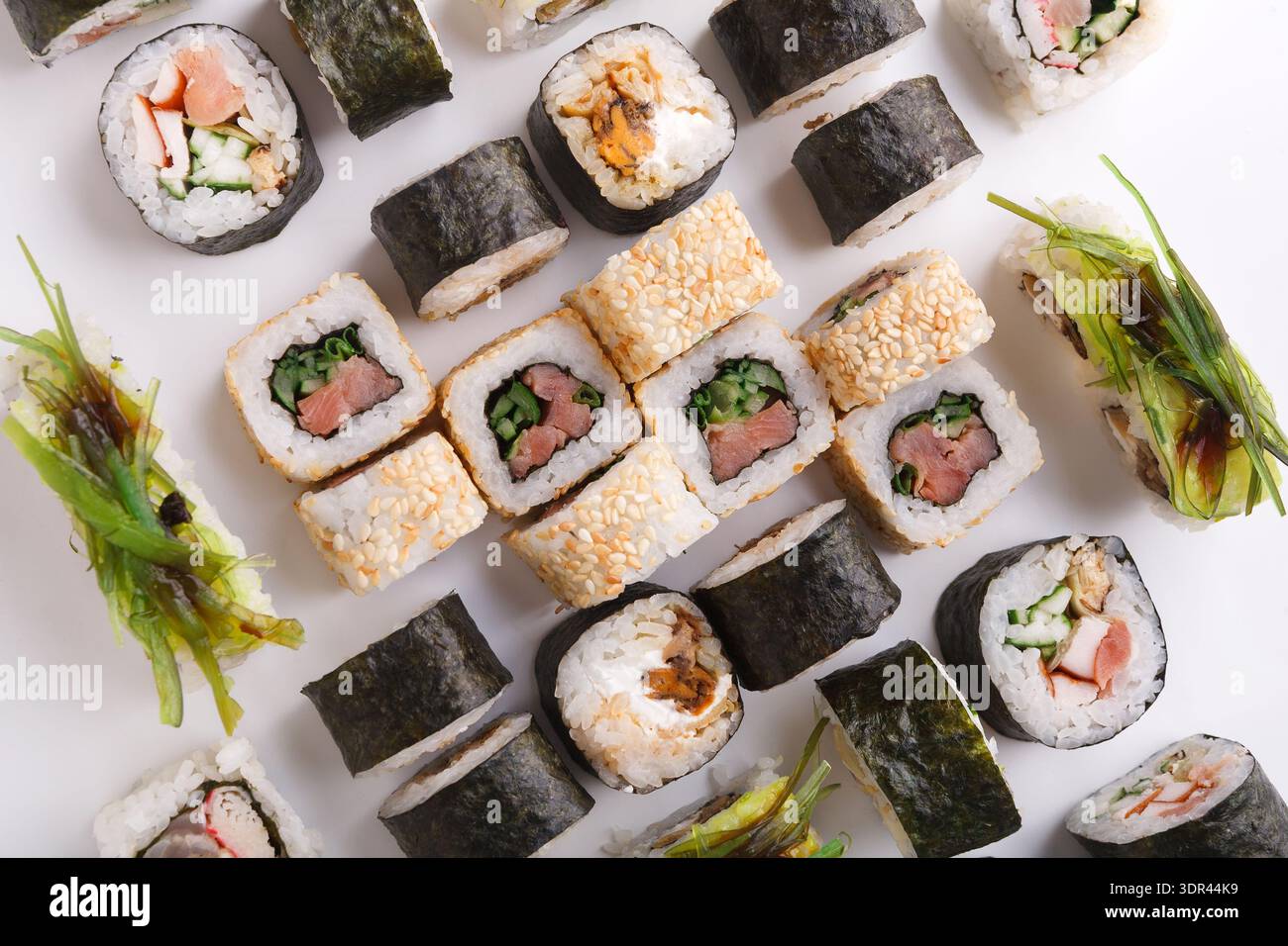 Collage di sushi con vari tipi e stili di rotoli di sushi su una superficie bianca Foto Stock