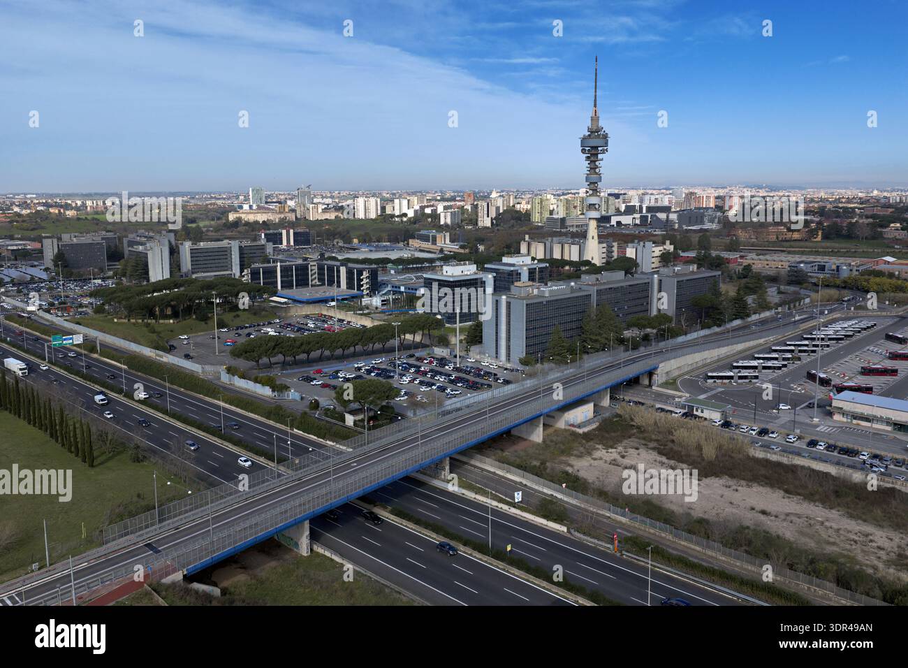 Vista aerea di un paesaggio urbano moderno, dove un'alta torre di comunicazione perfora lo skyline sopra strade ed edifici, Roma, Lazio, Italia. Foto Stock