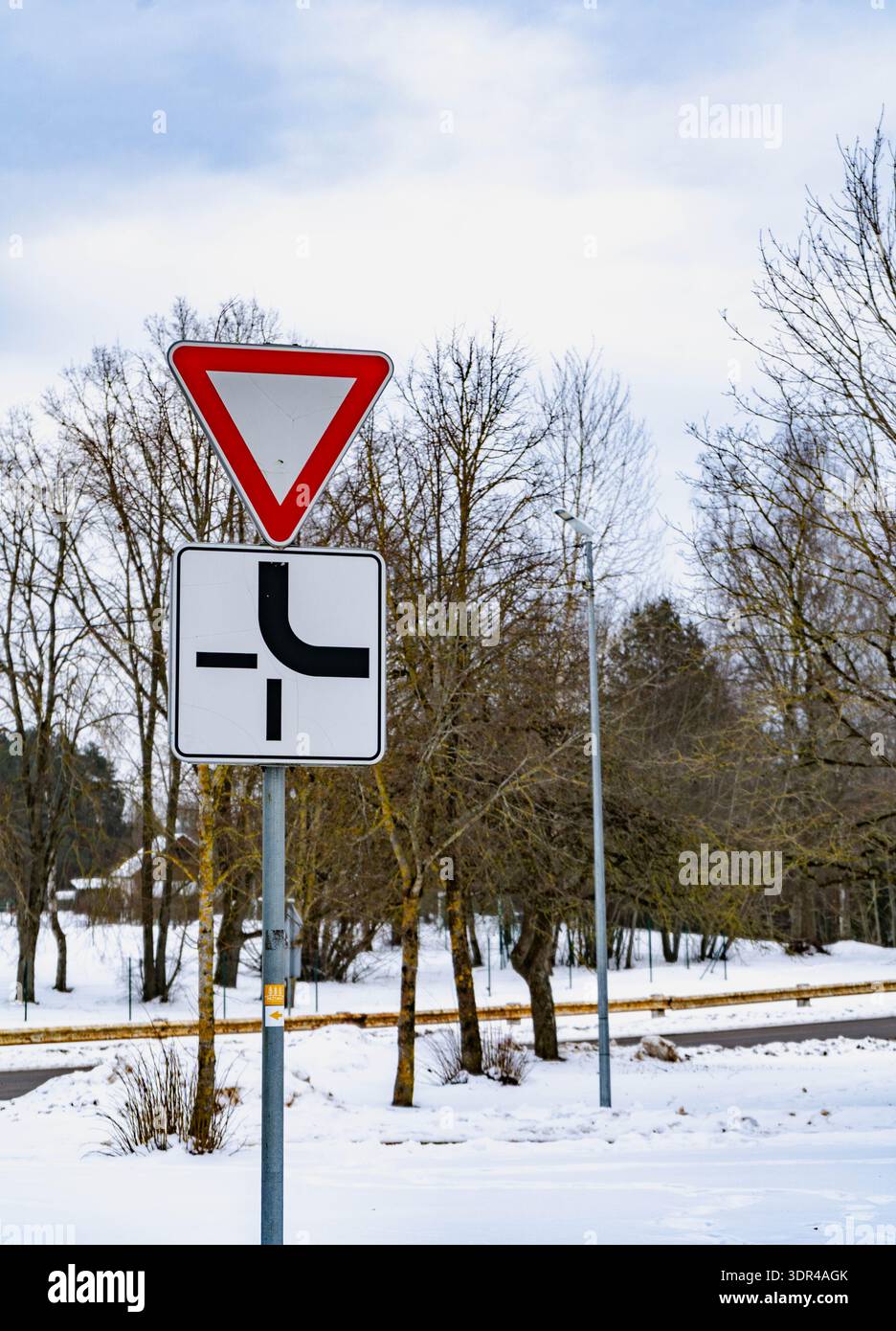 Segnale stradale di resa con schema di giunzione prioritaria in inverno, Lettonia Foto Stock