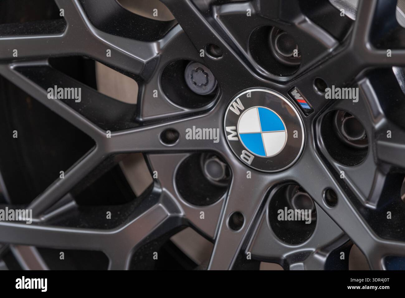 Primo piano del cerchione BMW con logo e razze in lega moderna, dettagli di design automobilistico di lusso e marchio premium Foto Stock
