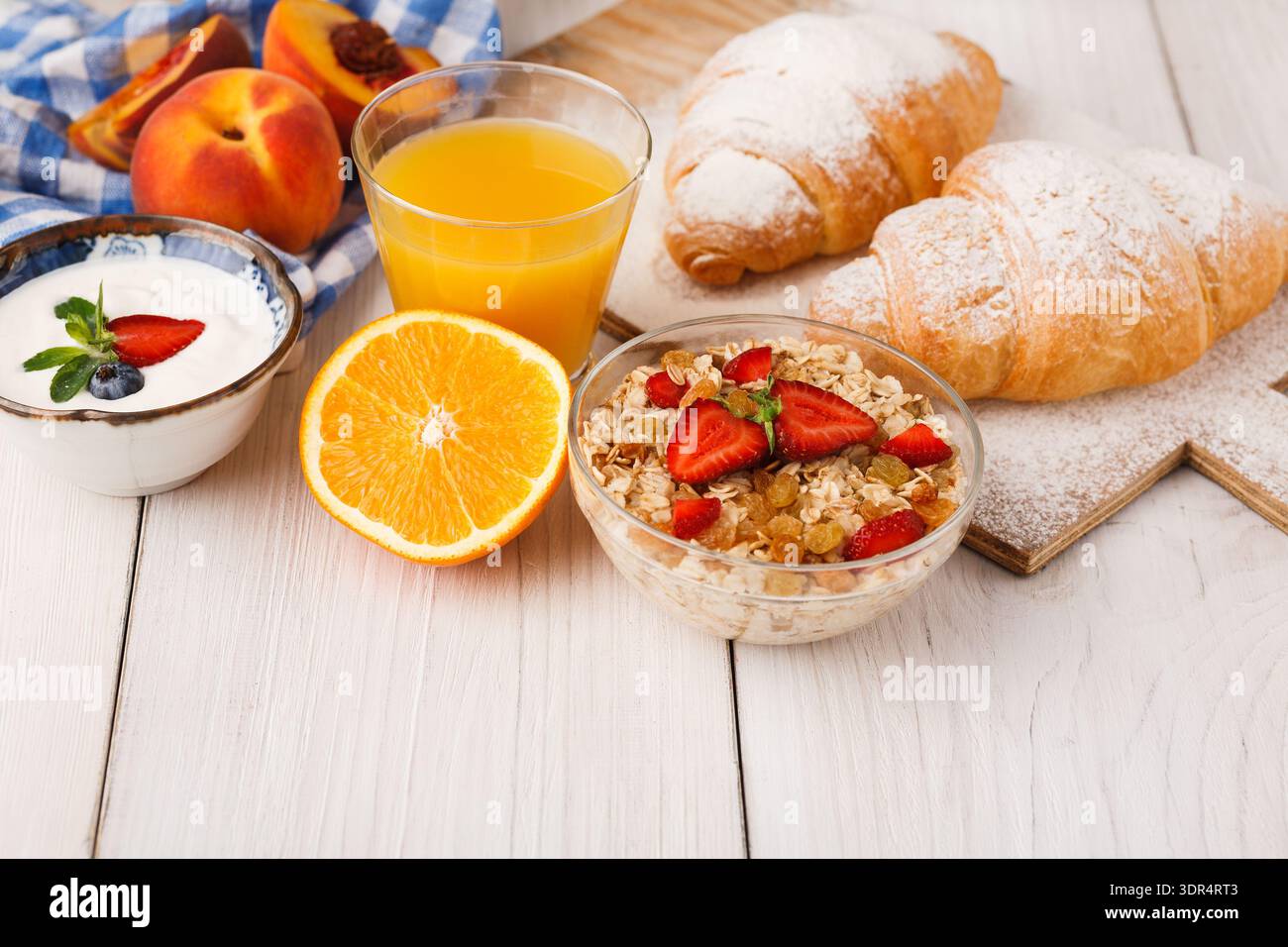 Colazione a buffet con frutta, yogurt, Granola e croissant su un tavolo di legno Foto Stock