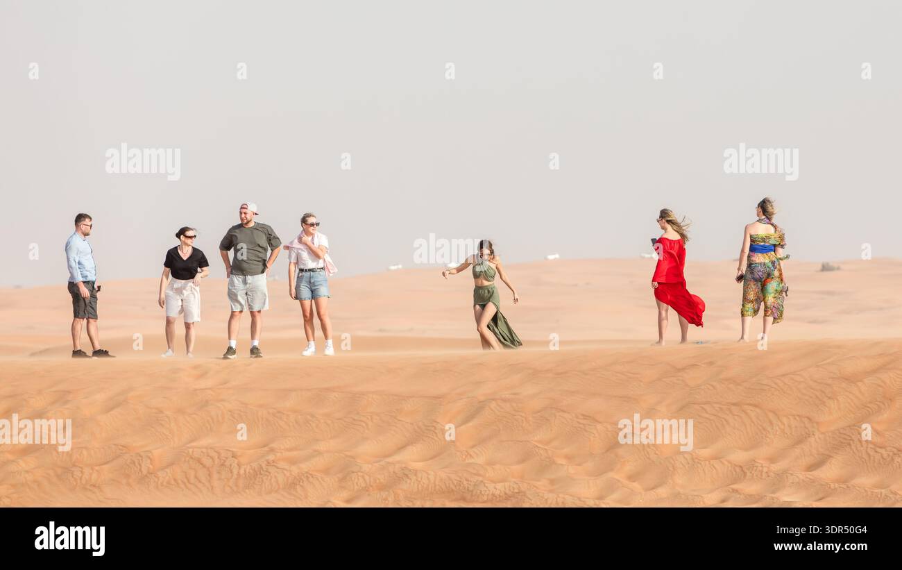 Dubai, Emirati Arabi Uniti - 9 marzo 2025: Atmosfera da viaggio nel deserto mentre i turisti si trovano sul crinale delle dune vicino a Dubai, Emirati Arabi Uniti, momento del deserto sociale per inter Foto Stock