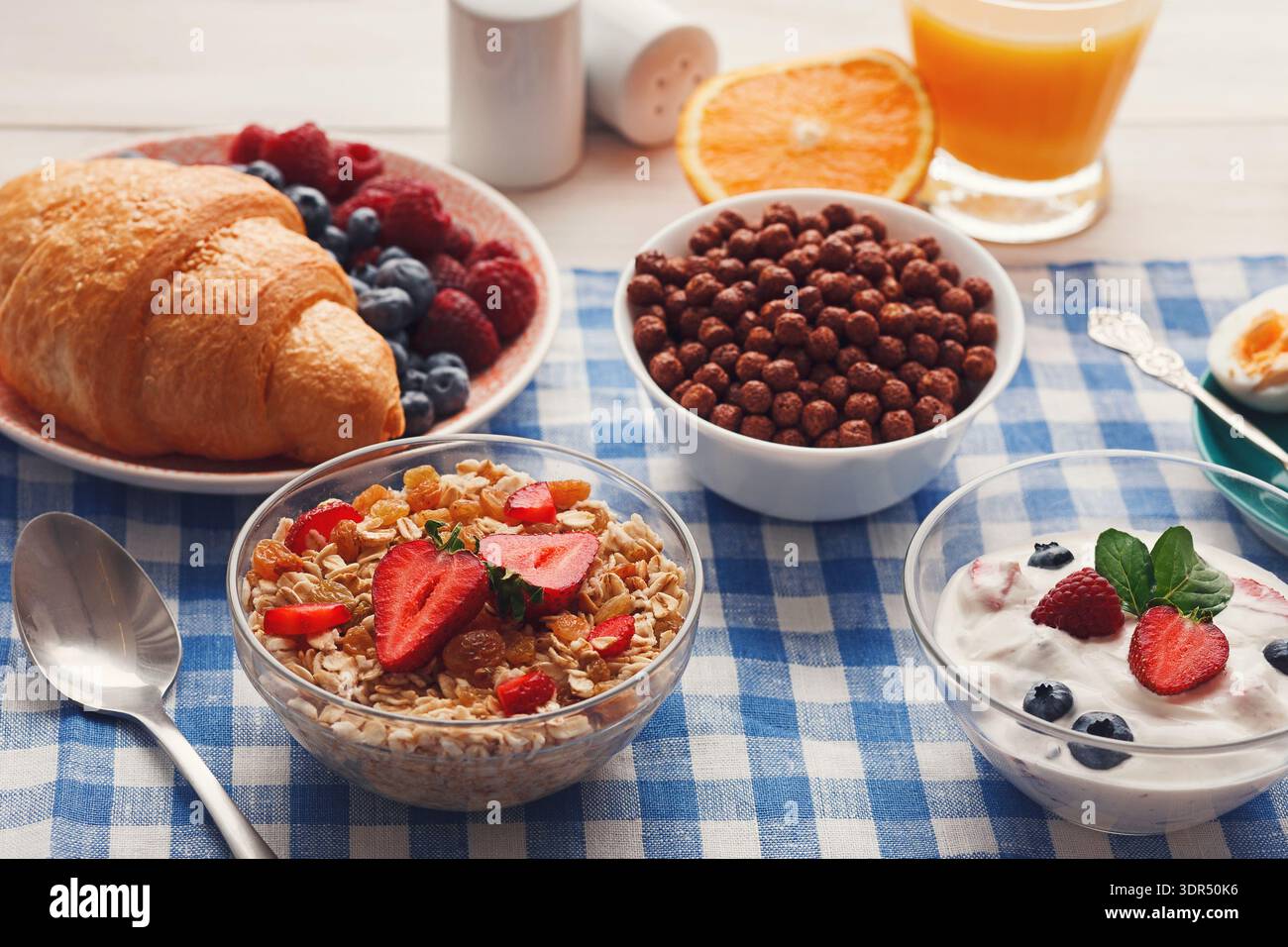 Deliziosa colazione a buffet con vari cibi e bevande su un tovaglia a scacchi Foto Stock