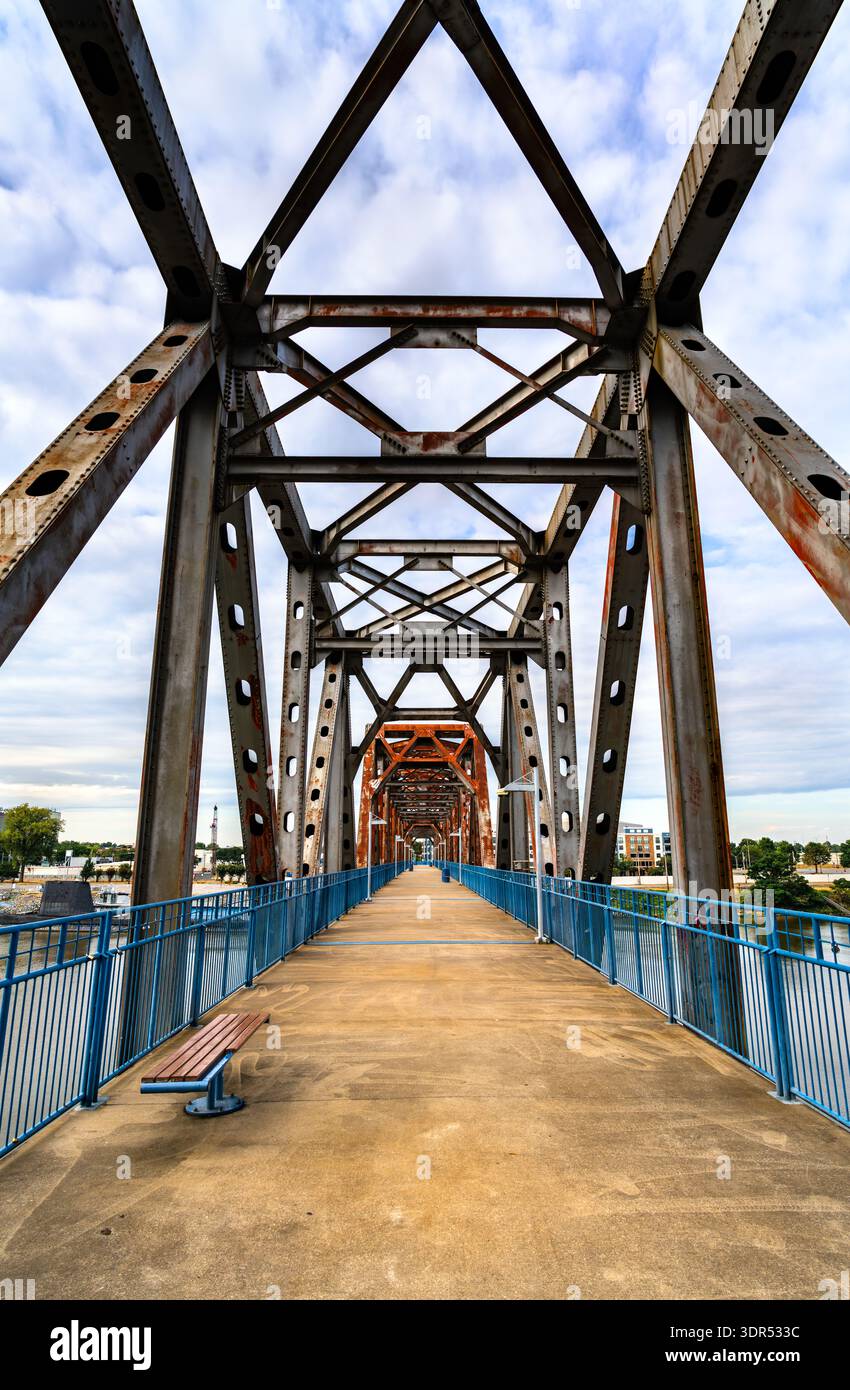 Clinton Presidential Park Bridge a Little Rock, Arkansas. Storico ponte ferroviario riadattato presenta una struttura a capriata in acciaio arrugginito e ringhiere blu sul fiume Arkansas Foto Stock