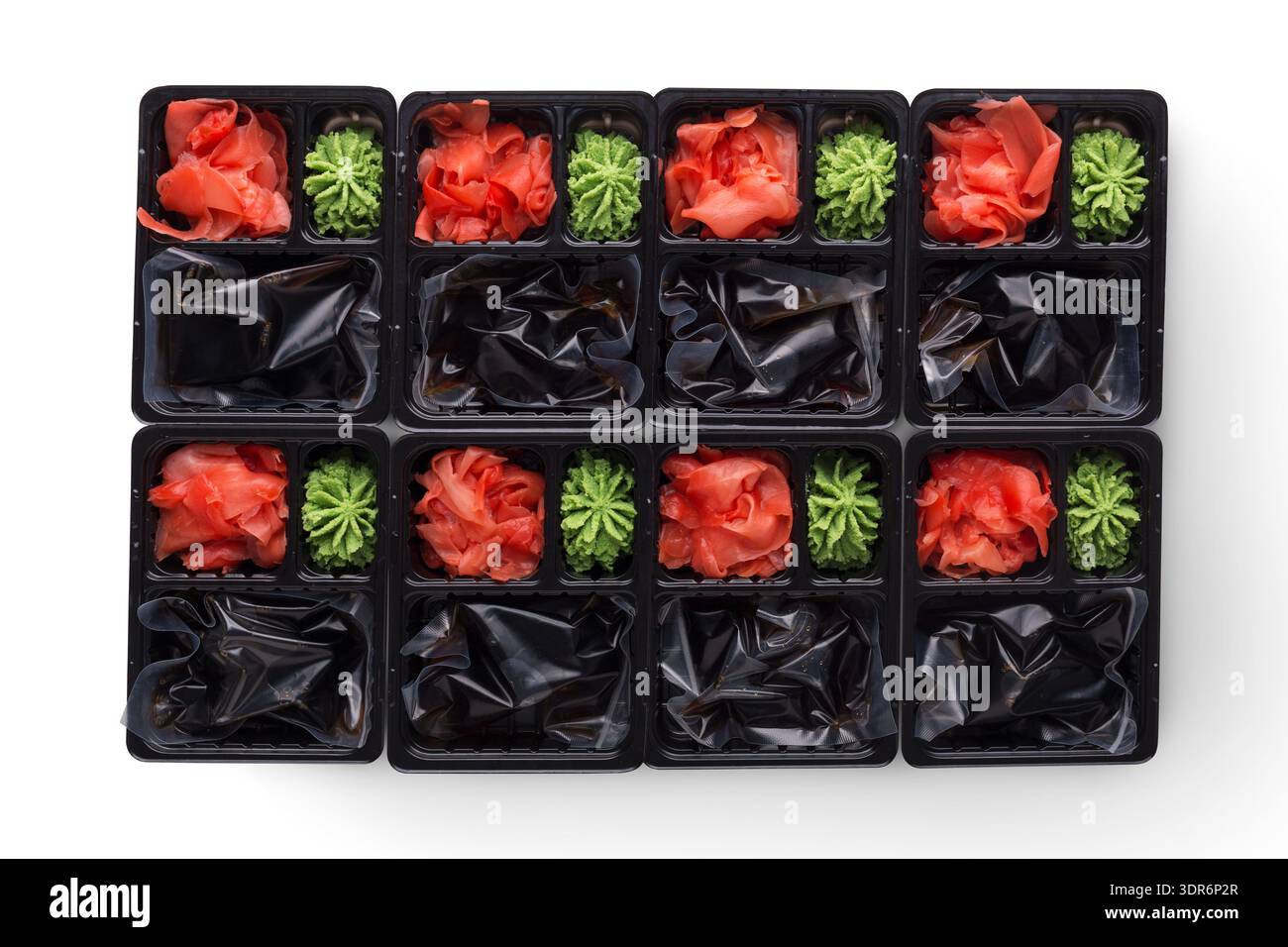 Contenitori con Wasabi verde e zenzero rosso disposti in scatole per la preparazione del sushi Foto Stock