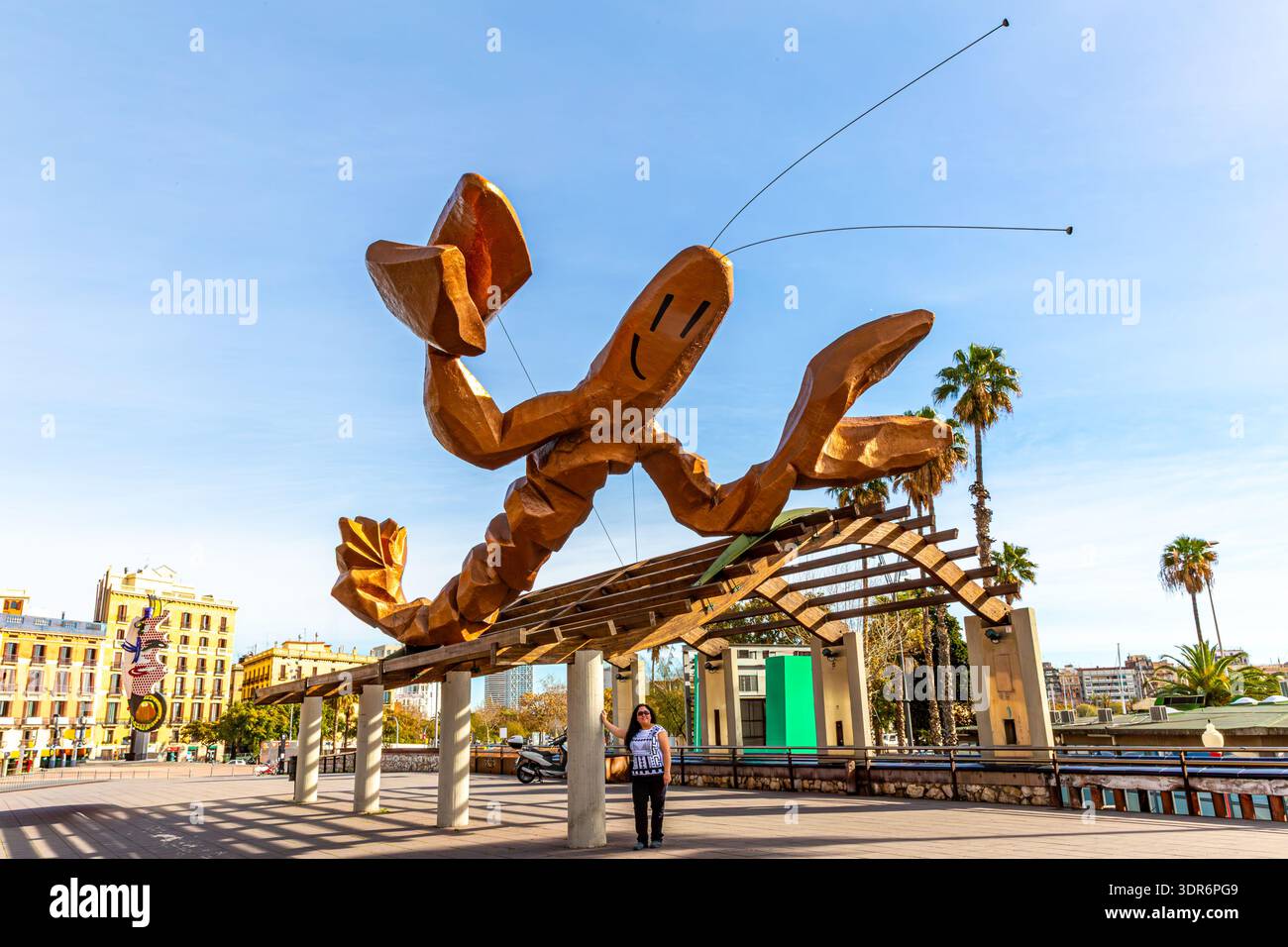 Passeig del Colom con una turista donna in piedi di fronte alla scultura la Gambrinus a Port Vell, scultura di aragosta gigante con faccia sorridente, buildi Foto Stock