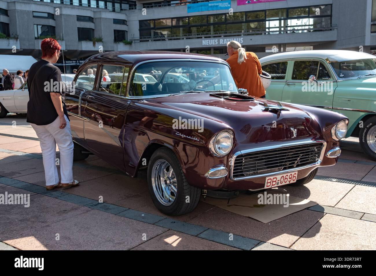 Pforzheim Germany Cream Vintage Compact Car parcheggiata su ciottoli, accanto al Glass Storefront con riflessi cromati, fari rotondi e manubrio lucidato Foto Stock