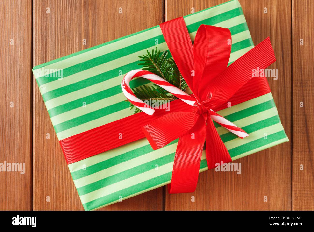Confezione regalo in verde e rosso con Candy Cane su una superficie in legno Foto Stock