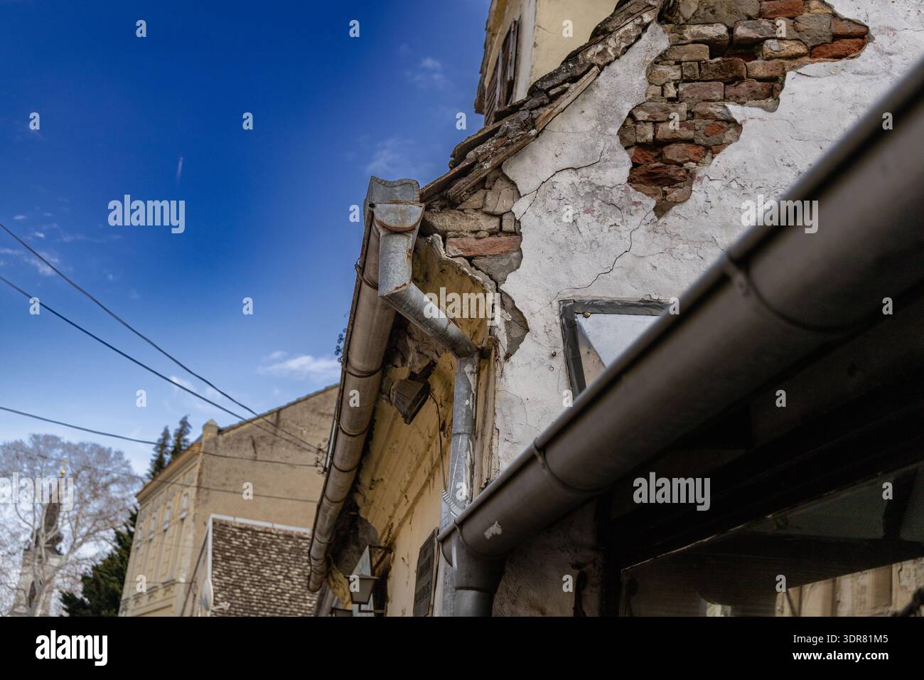 Vecchio edificio urbano con pareti in mattoni incrinate Foto Stock