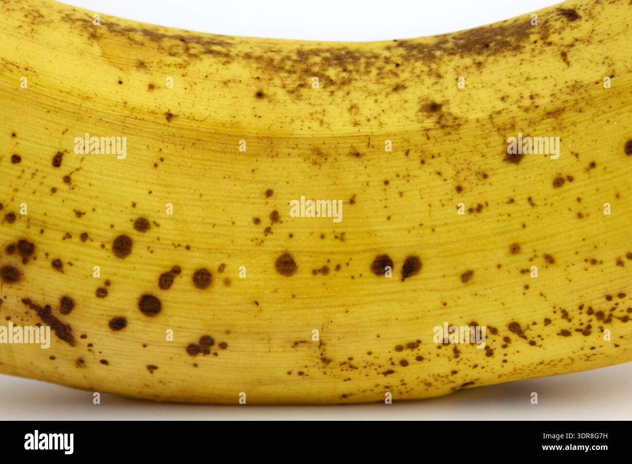 Vista macro dettagliata di una buccia di banana gialla matura con macchie e consistenza naturali di zucchero di canna Foto Stock