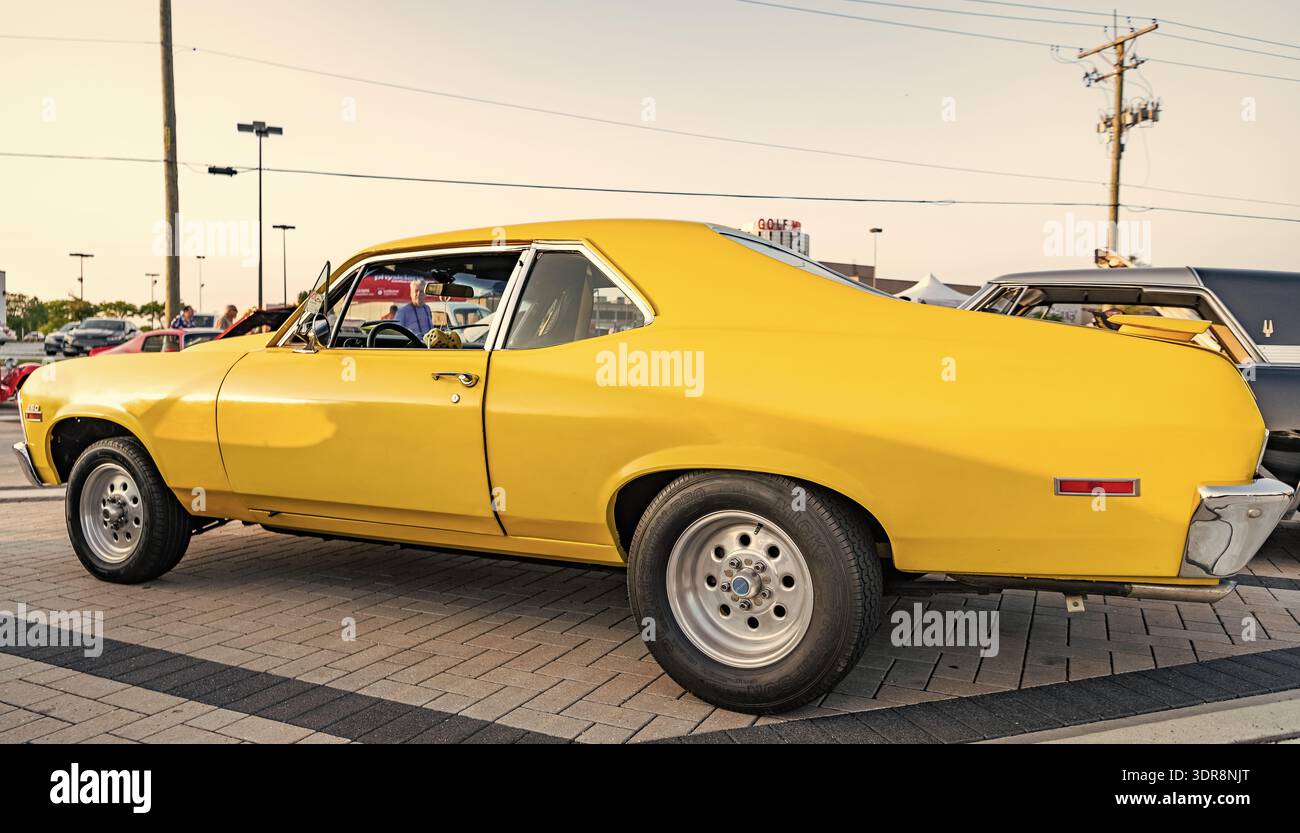Park Ridge, Illinois, USA - 21 agosto 2024: Auto gialla della Chevrolet Nova SS. Chevy Camaro fuori. auto gialla parcheggiata durante l'esposizione automatica, vista laterale. 1972 Foto Stock