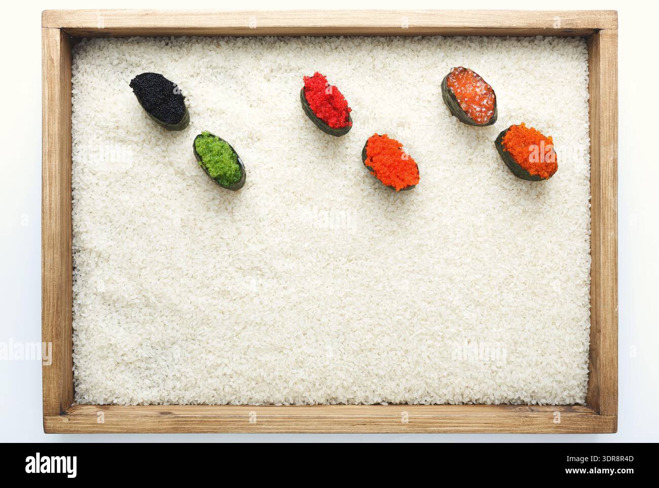 Vari tipi di Fish Roe serviti su un letto di riso bianco in un vassoio di legno per la presentazione Foto Stock