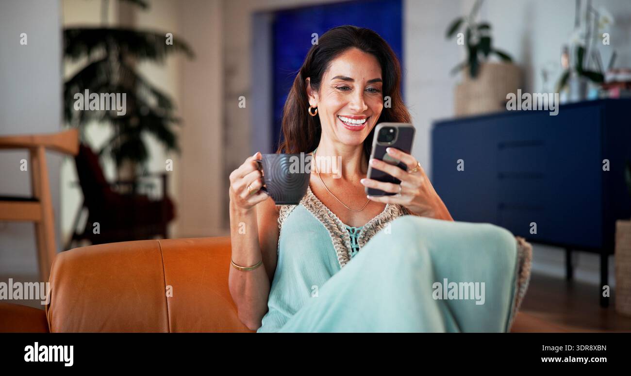 Caffè, telefono e relax con la donna sul divano per app per incontri, social media e messaggi di testo. Sito Web di matchmaking, forum di relazioni online e. Foto Stock