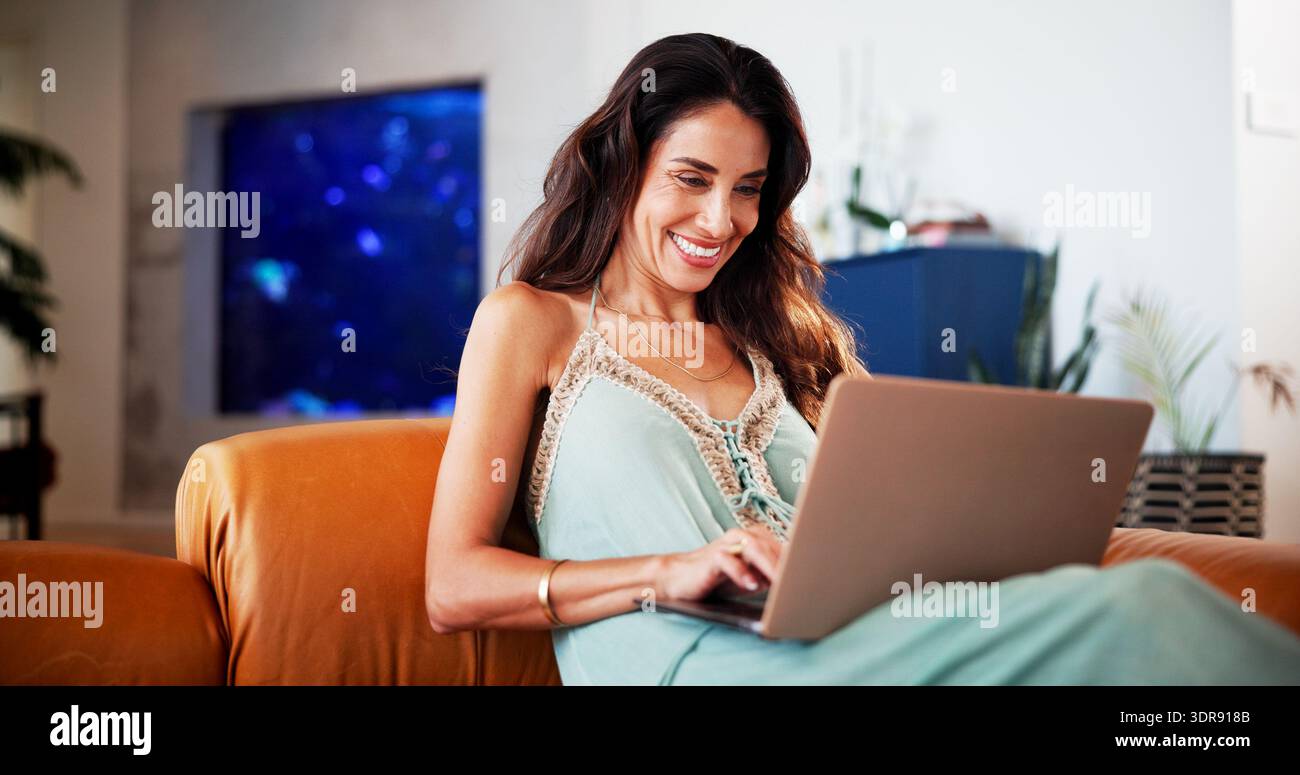 Rilassatevi, con un laptop o una donna felice con lo streaming sul divano, il binge watching del fine settimana o cercate una serie di comfort. Navigazione, pc o persona matura che digita per Foto Stock