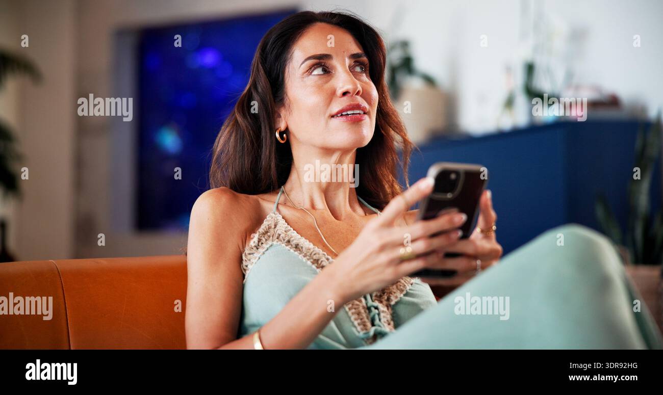 Pensare, telefonare e rilassarsi con la donna sul divano per l'app di incontri, social media e messaggi di testo. Sito Web di matchmaking, forum di relazioni online e. Foto Stock