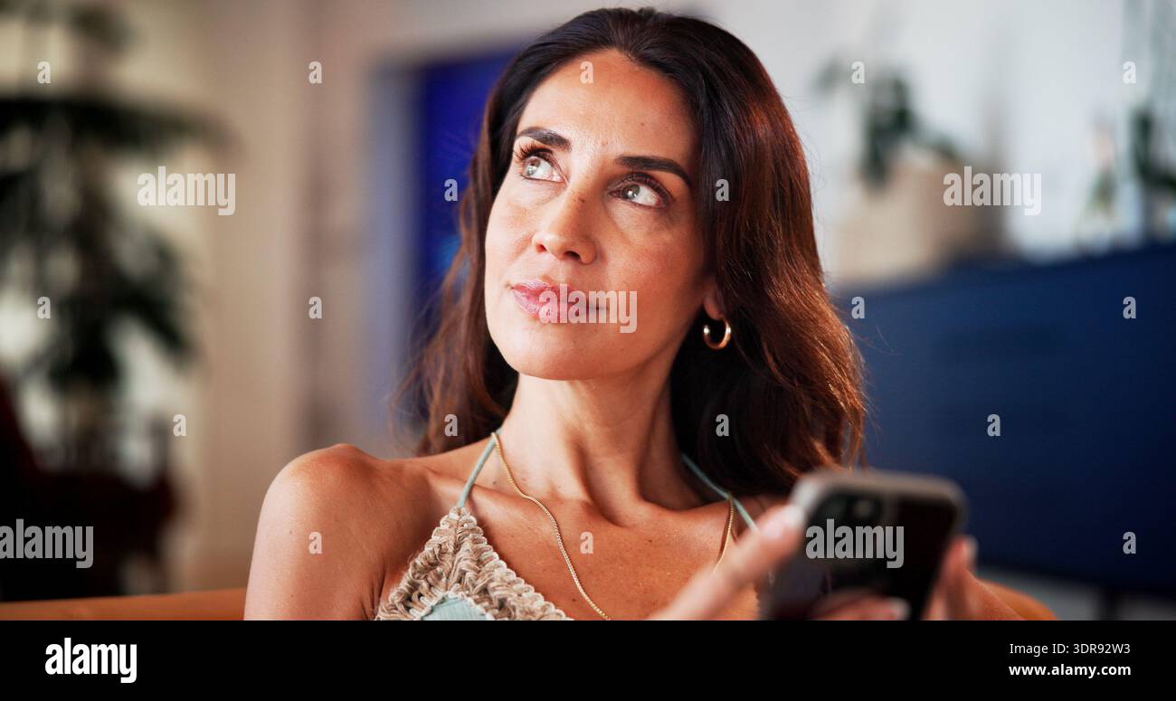 Guarda, telefona e rilassati con una donna sul divano per app per incontri, social media e SMS. Sito Web di matchmaking, forum di relazioni online e. Foto Stock