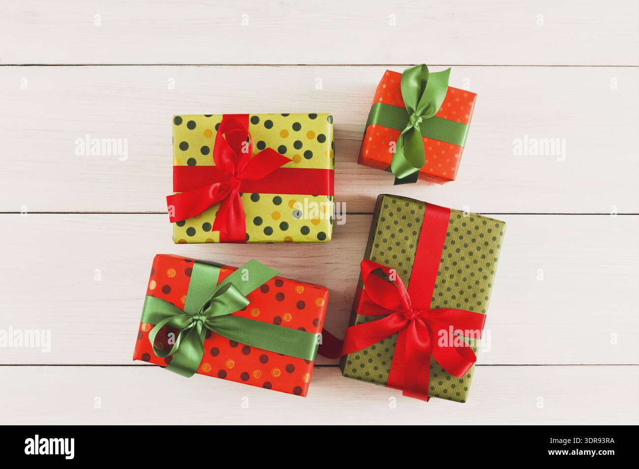 Collage di confezioni regalo avvolte in carta colorata e nastri su una superficie in legno Foto Stock