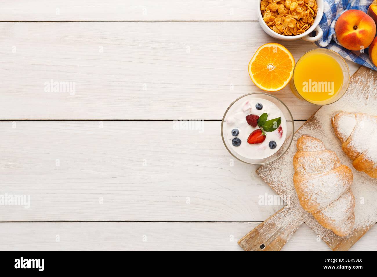 Una collezione di cibi per la colazione è disposta su un tavolo di legno Foto Stock