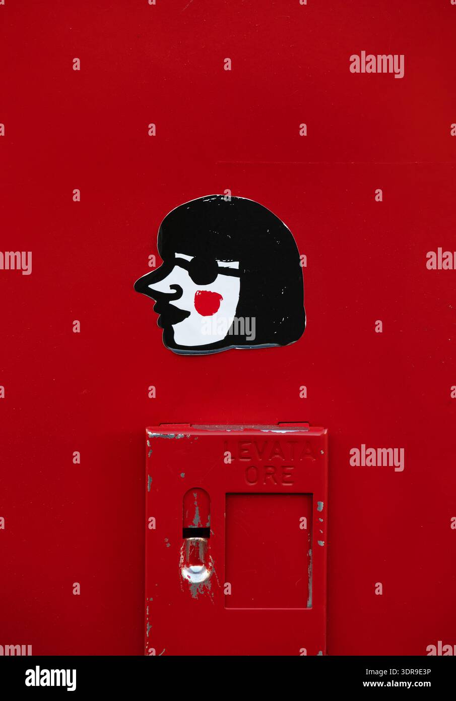 Primo piano estremo di un adesivo di profilo femminile illustrato bianco e nero con dettaglio di guancia rossa applicato alla superficie metallica rosso brillante di un po italiano Foto Stock