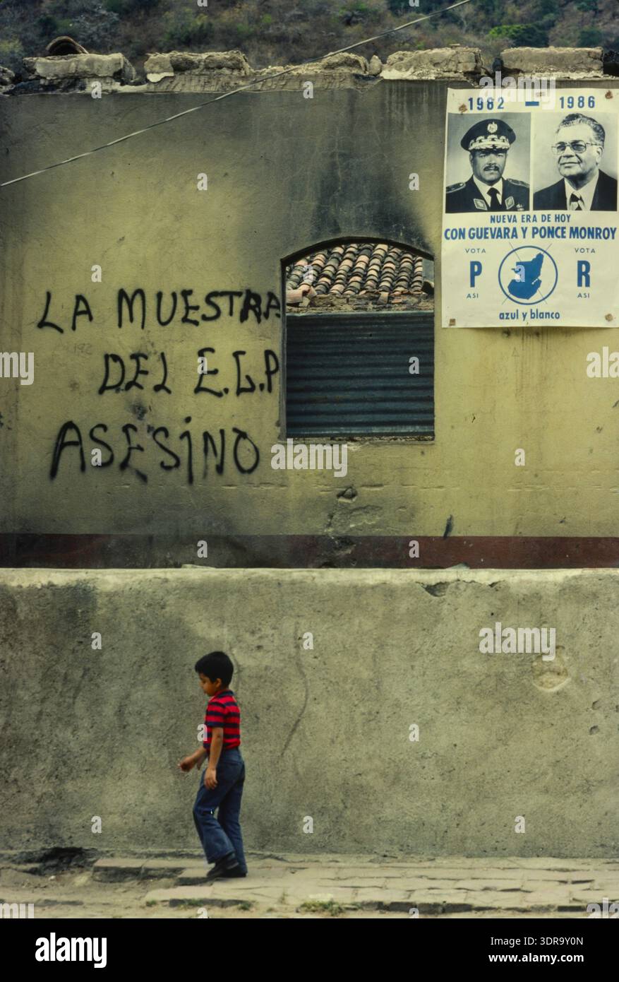 Un ragazzo cammina oltre il materiale elettorale e i graffitti politici, città del Guatemala, febbraio 1982 Foto Stock