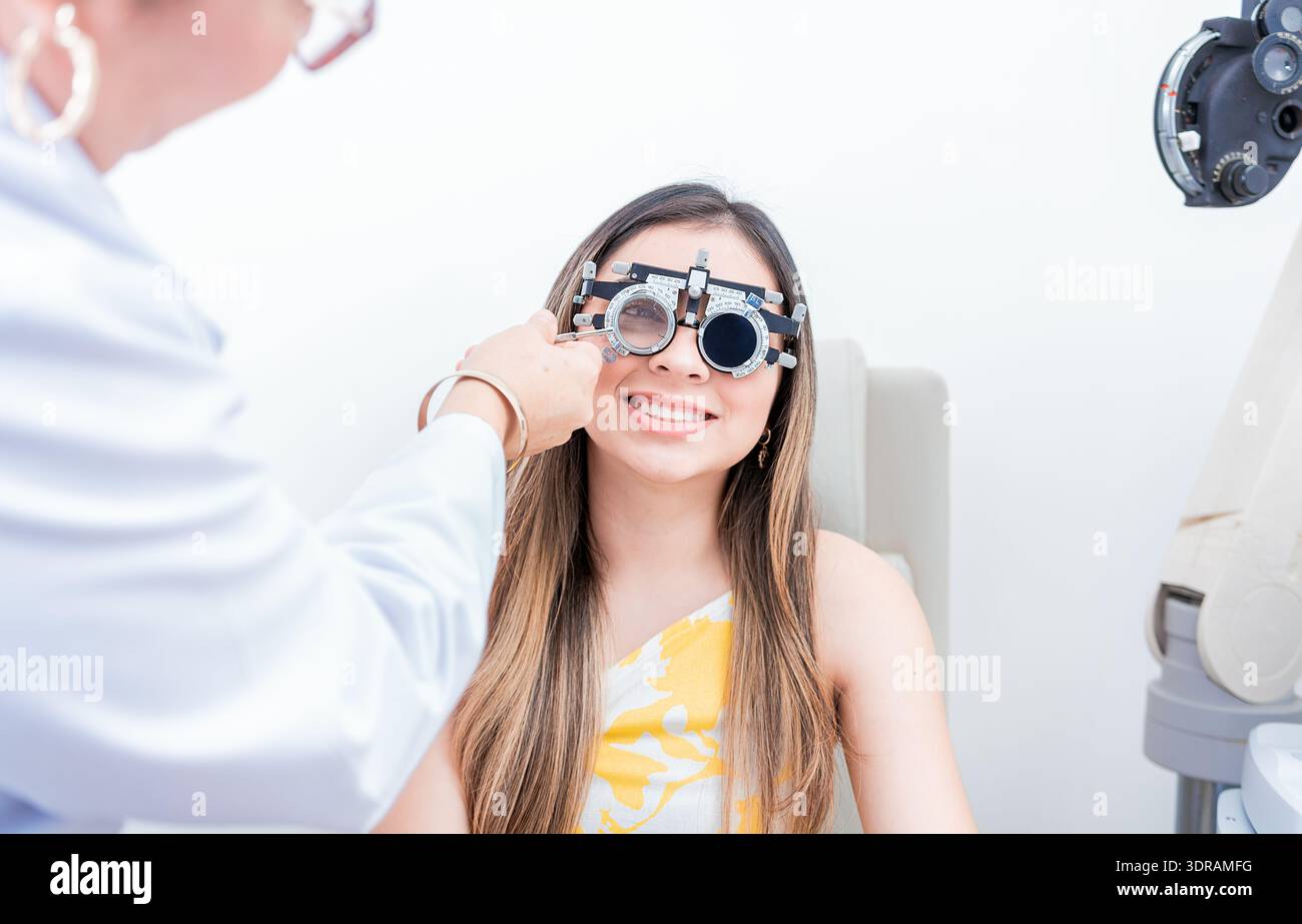 Paziente sorridente con telaio di prova optometrista. Primo piano dell'optometrista che esamina il paziente con il telaio di prova optometrista Foto Stock