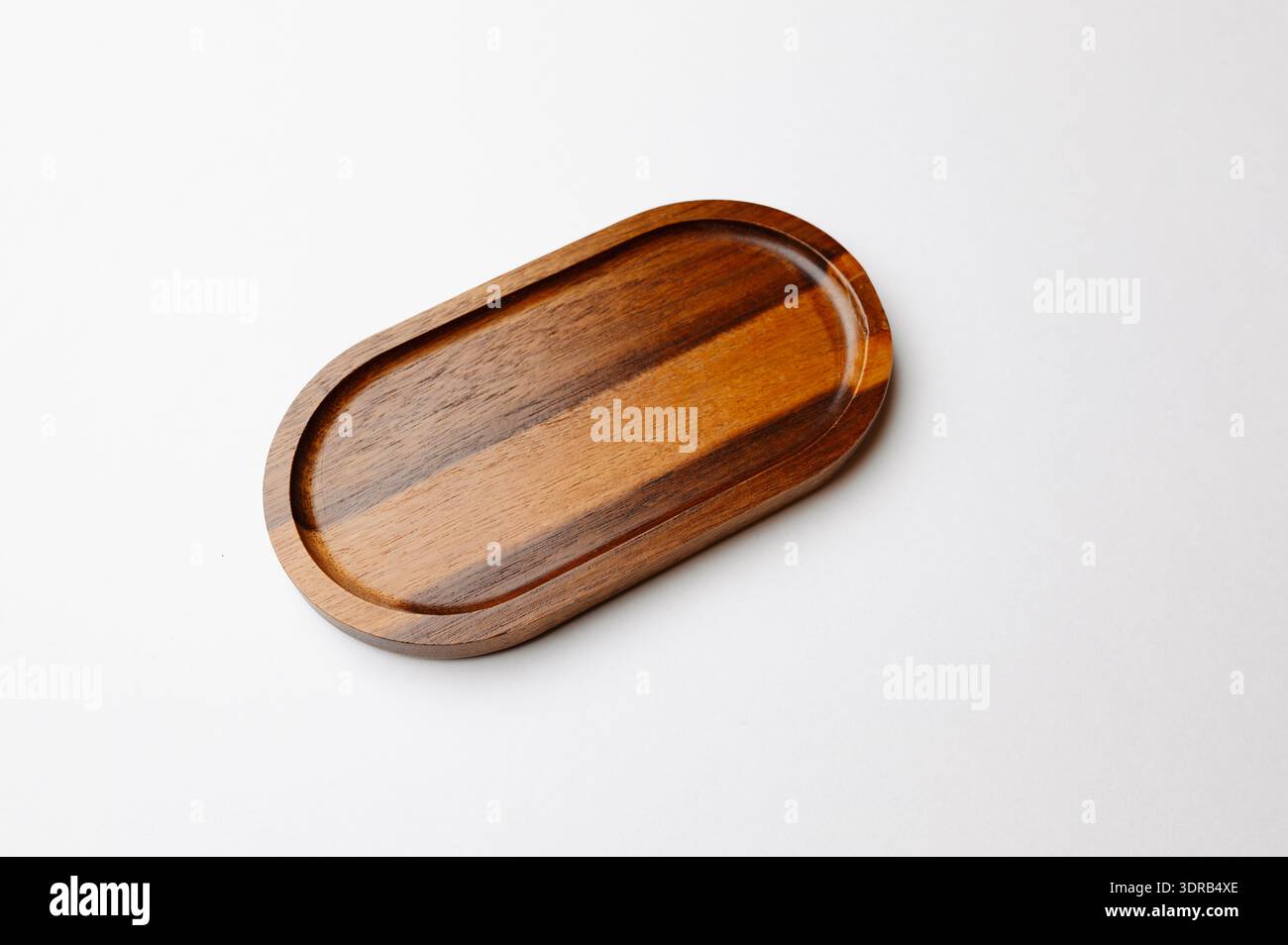 Elegante piatto da portata in noce scuro. Legno lucido contemporaneo con dettagli a righe Foto Stock